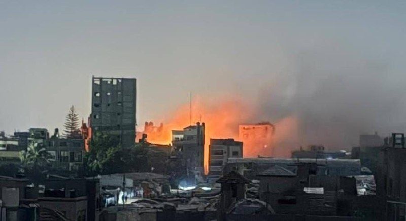 להבות ועשן עולים בין בניינים בשטח עירוני.